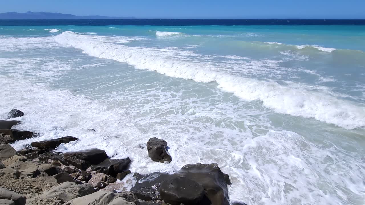 Azure Mediterranean Drama: White Foam on Rocky Shore, Sea Waves Splashing Against Cliffs - Nature's Breathtaking Coastal Spectacle