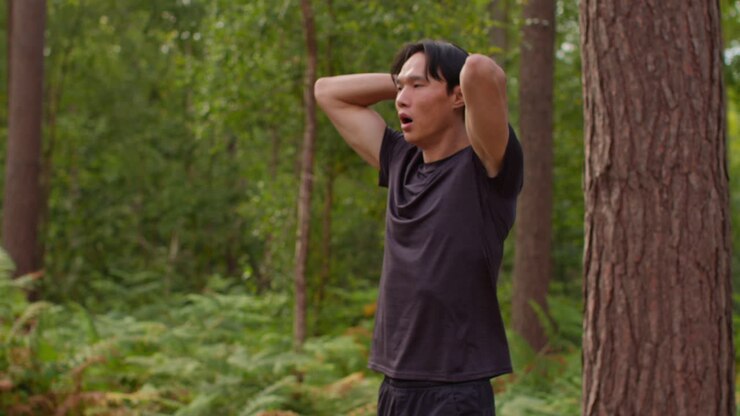 Tired Mid Adult Man Exercising Doing Work Out Outdoors Running Along Track In Forest Stopping For Breath And Checking Activity App On Smart Watch Shot In Real Time 1