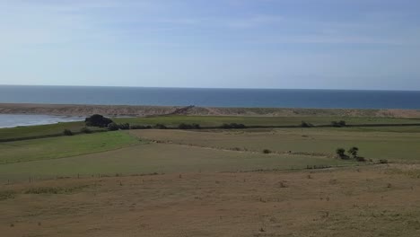 Aerial-tracking-and-rotating-from-right-to-left-looking-across-the-fleet-lagoon-and-Chesil-Beach,-Dorset,-England