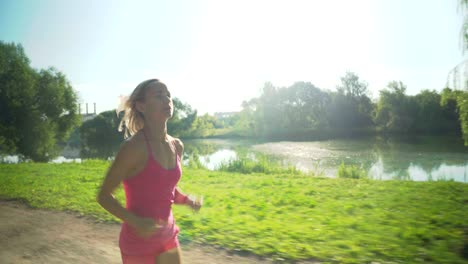 young caucasian woman jogging in public park near the river