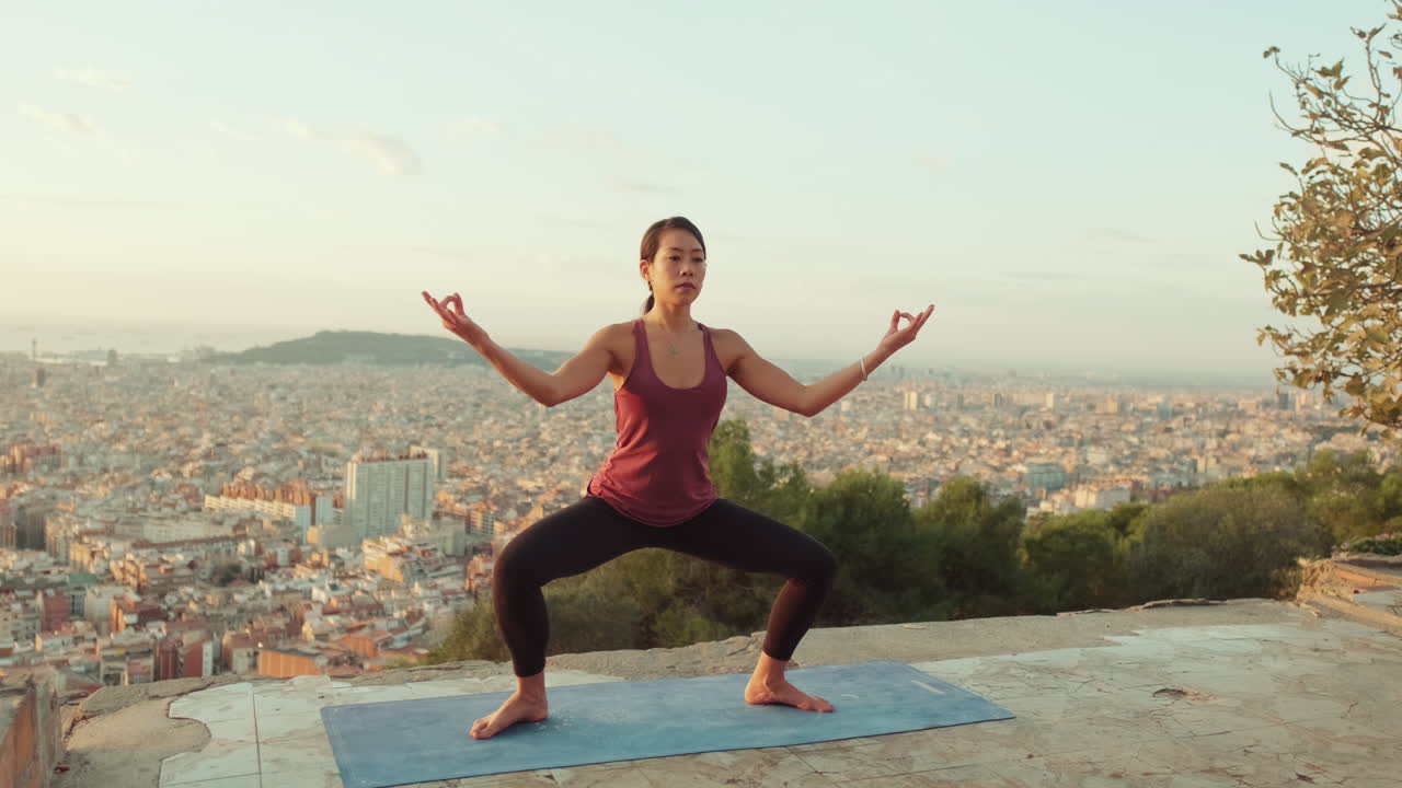 Arka planda şehir manzarası olan, açık havada yoga yapan kadın