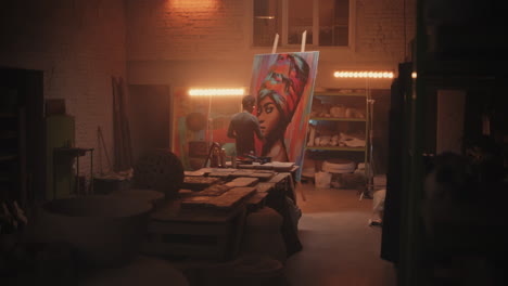 artist working on a colorful portrait in a studio