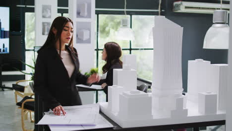 architecture office employee looking at building model