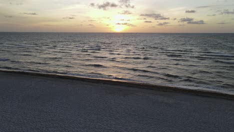 Ikonischer-Sonnenaufgang-Am-Strand,-Luftflug-über-Den-Rettungsschwimmerturm-In-Richtung-Sonne