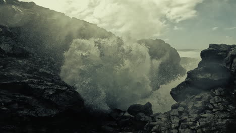 powerful ocean waves crashing against volcanic rocks