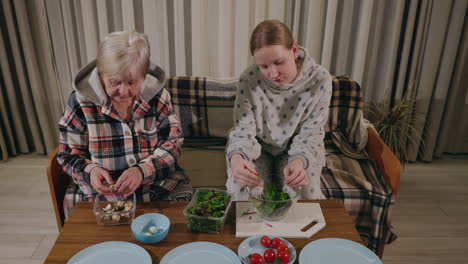 grandmother and granddaughter preparing a salad together