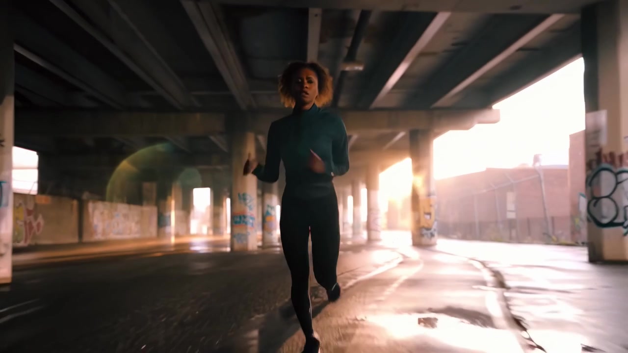 Young Woman Running Under Urban Overpass at Sunrise