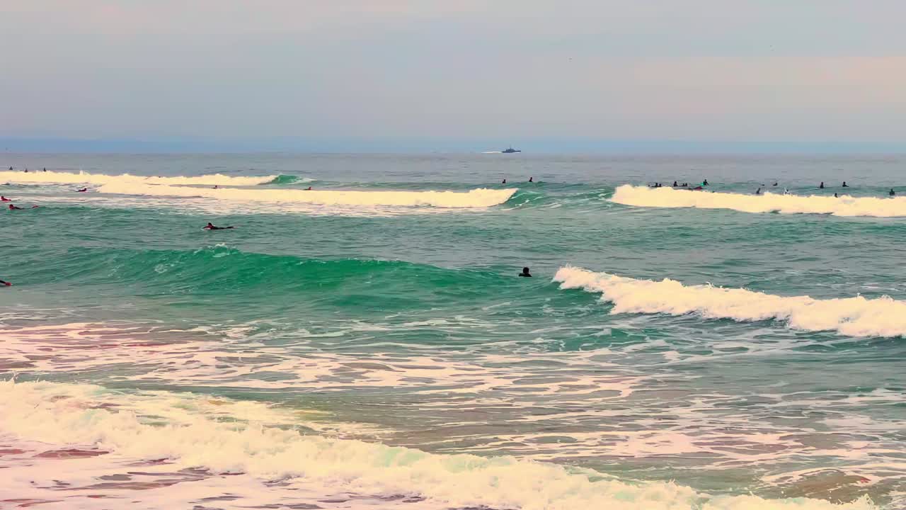 해변에서 놀고, 이야기와 팁을 공유하고, 서핑 커뮤니티의 여유로운 분위기를 즐기는 서퍼들의 사진