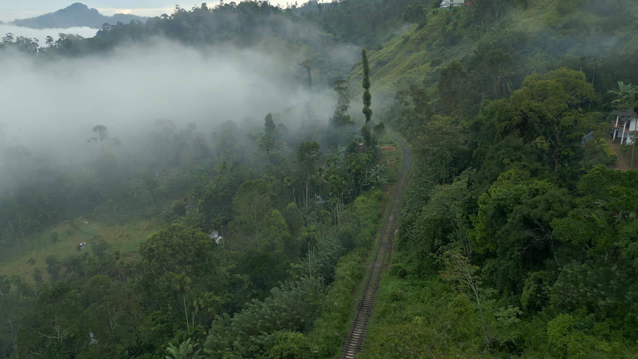 estableciendo una toma aérea de avión no tripulado de la línea de tren en las colinas de sri lanka en la niebla en ella sri lanka