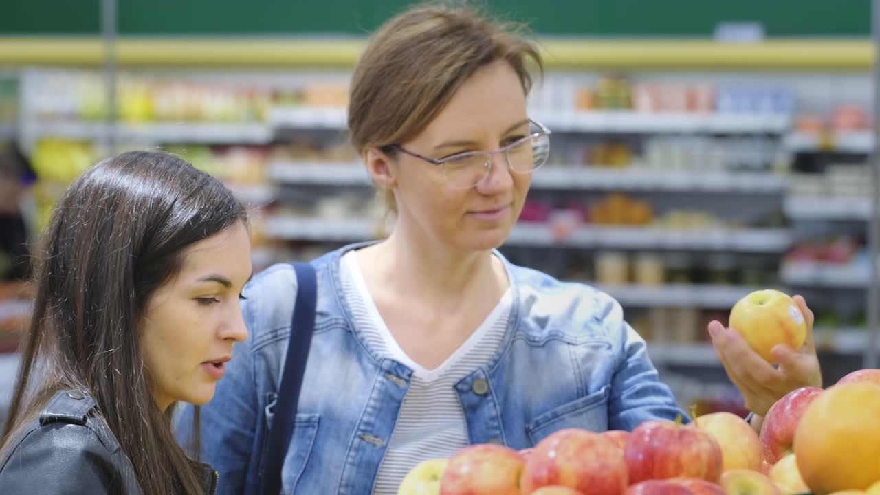 Women shopping for apples at a supermarket