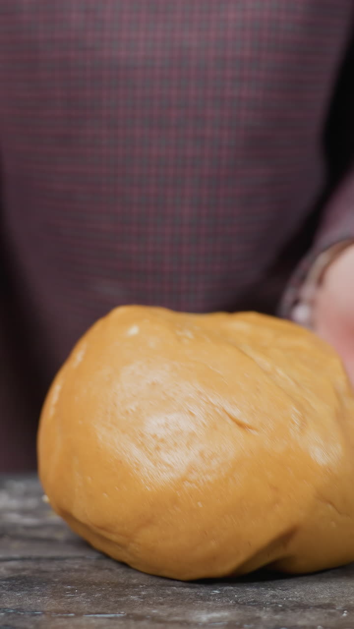 베이커가 반죽을 고, 그것을 들어 올리고, 부 테이블에 떨어뜨리는 모습, 손이 움직이고, 반죽이 공중에 서서히, 밀가루 먼지가 표면에, 현대 부 설정 배경