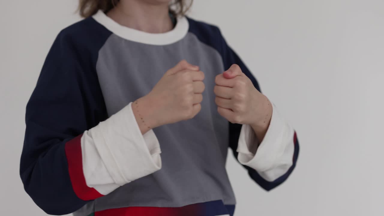 A child with a t-shirt holding his fists up