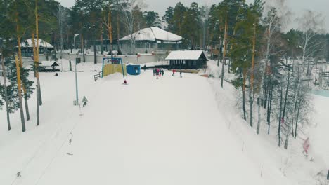 personas con trajes de esquí miran al snowboarder deslizándose por la pendiente.