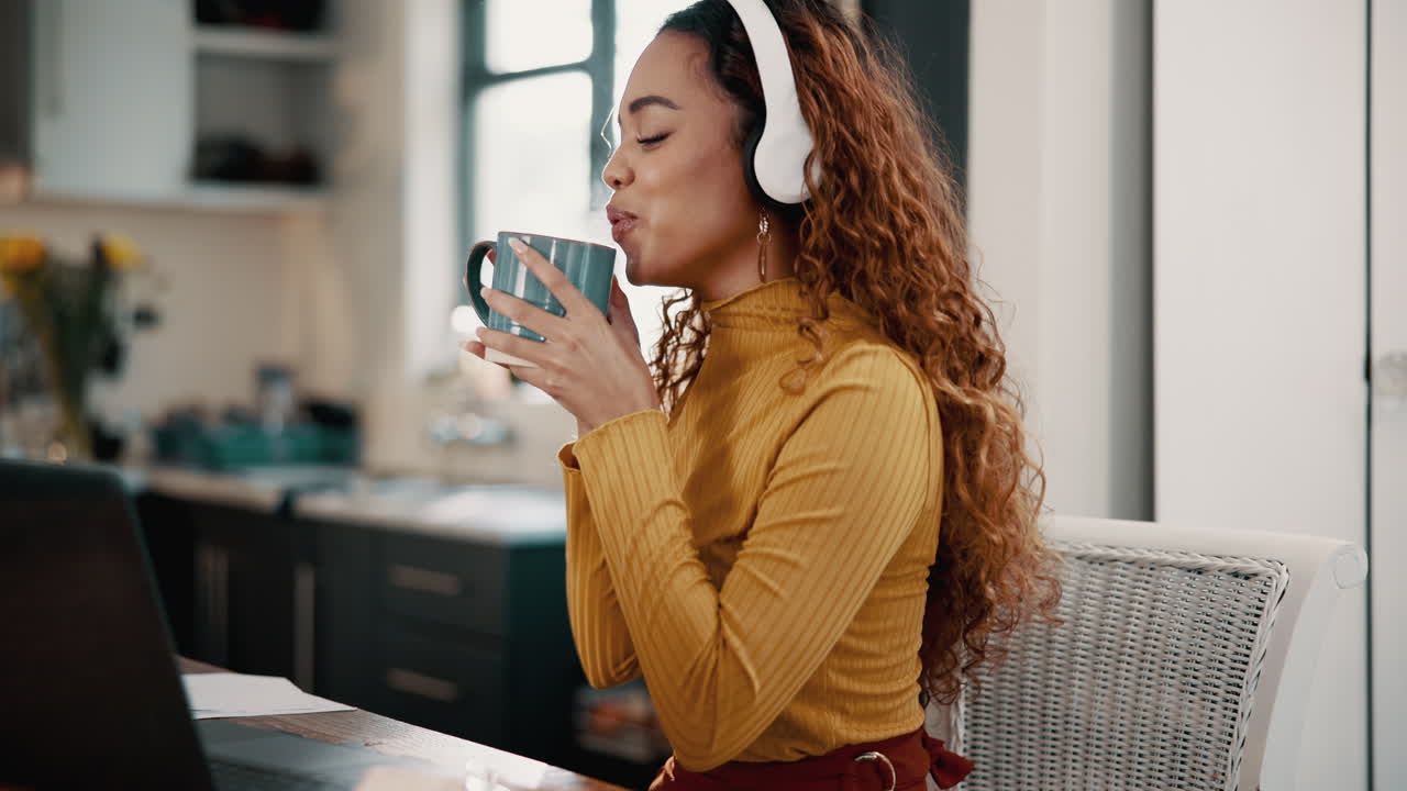 Woman working from home, listening to music and drinking coffee