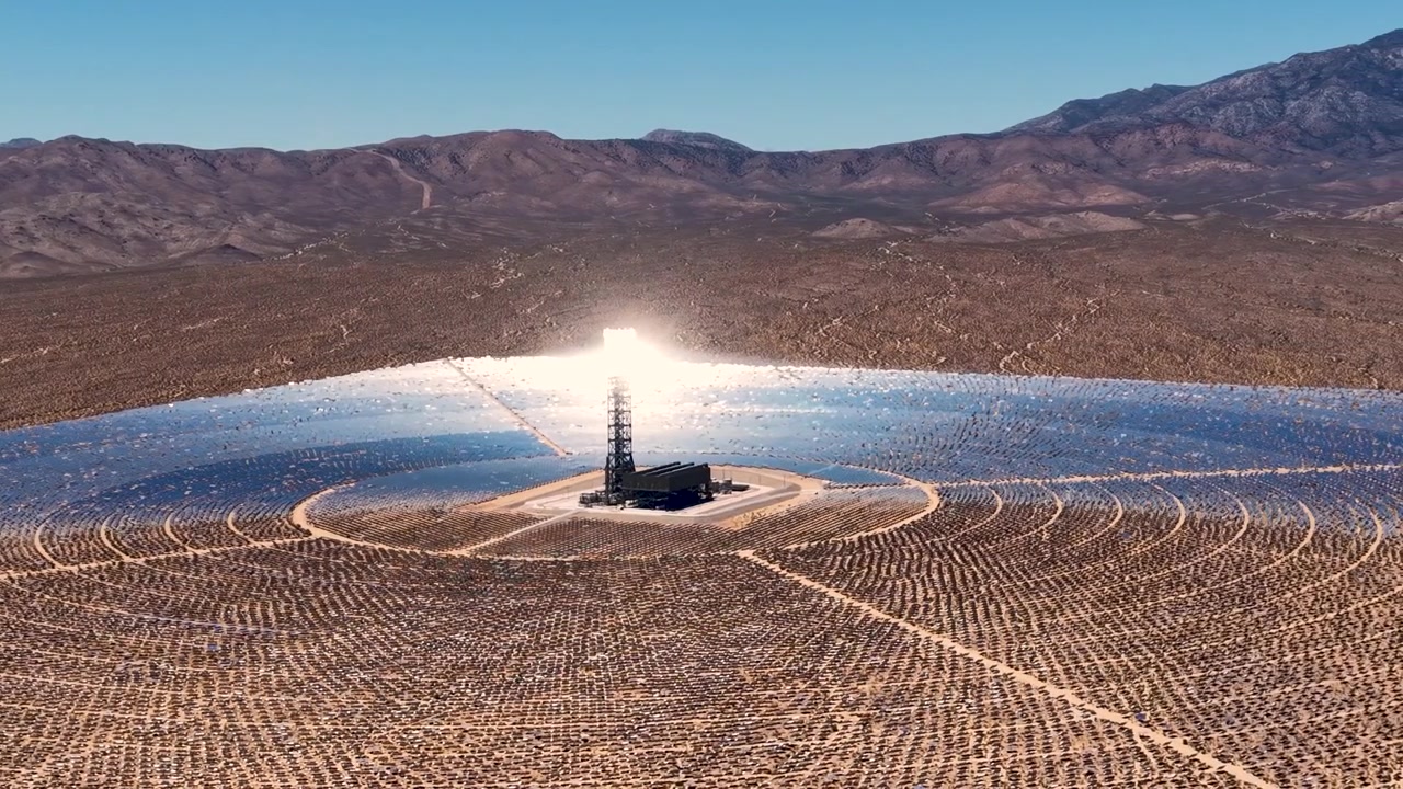 Dronen fanger den enorme skala af Ivanpah solcelleanlægget. Sollys danser hen over tusindvis af præcist justerede heliostater, hvis reflekterende overflader glimter i den varme Nevada-sol.