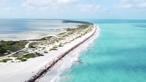 Aérea-De-Isla-Blanca,-México,-La-Vista-Aérea-Revela-Una-Escena-Pintoresca-Donde-Las-Olas-Rompen-Suavemente-Sobre-La-Prístina-Playa-De-Arena-Blanca