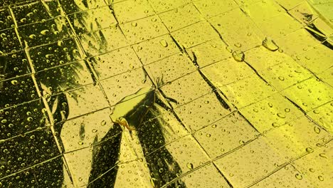 las gotas de lluvia caen sobre una manta de papel de aluminio de color dorado reflectante con textura cuadrada