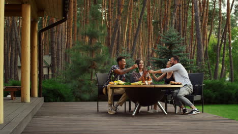 Young-people-having-chat-outside.-Fellows-relaxing-around-bbq-grill-outdoors