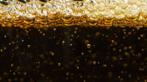 slow motion extreme closeup pouring apple cider limonade, black background