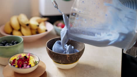 mujer, manos y preparar tazón de batido en casa