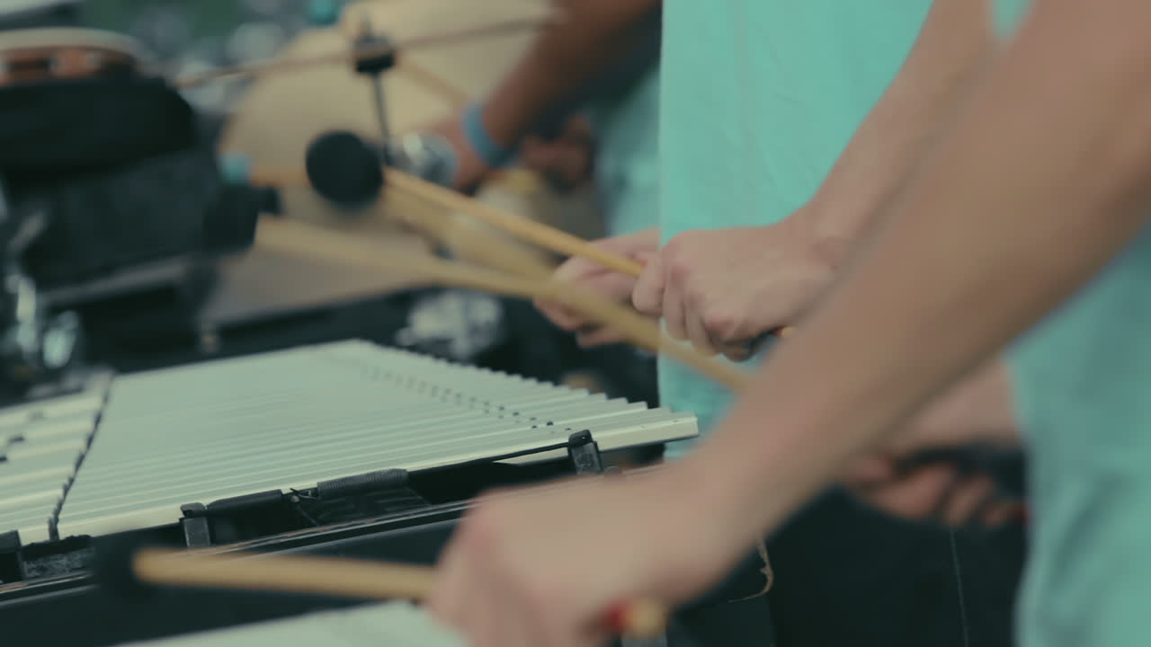 Cinematic closeup hands of high school marching band members playing xylophone and marimba in slow motion