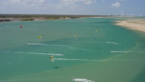 drone orbits above kitesurfers in shallow water at the brazil coastline