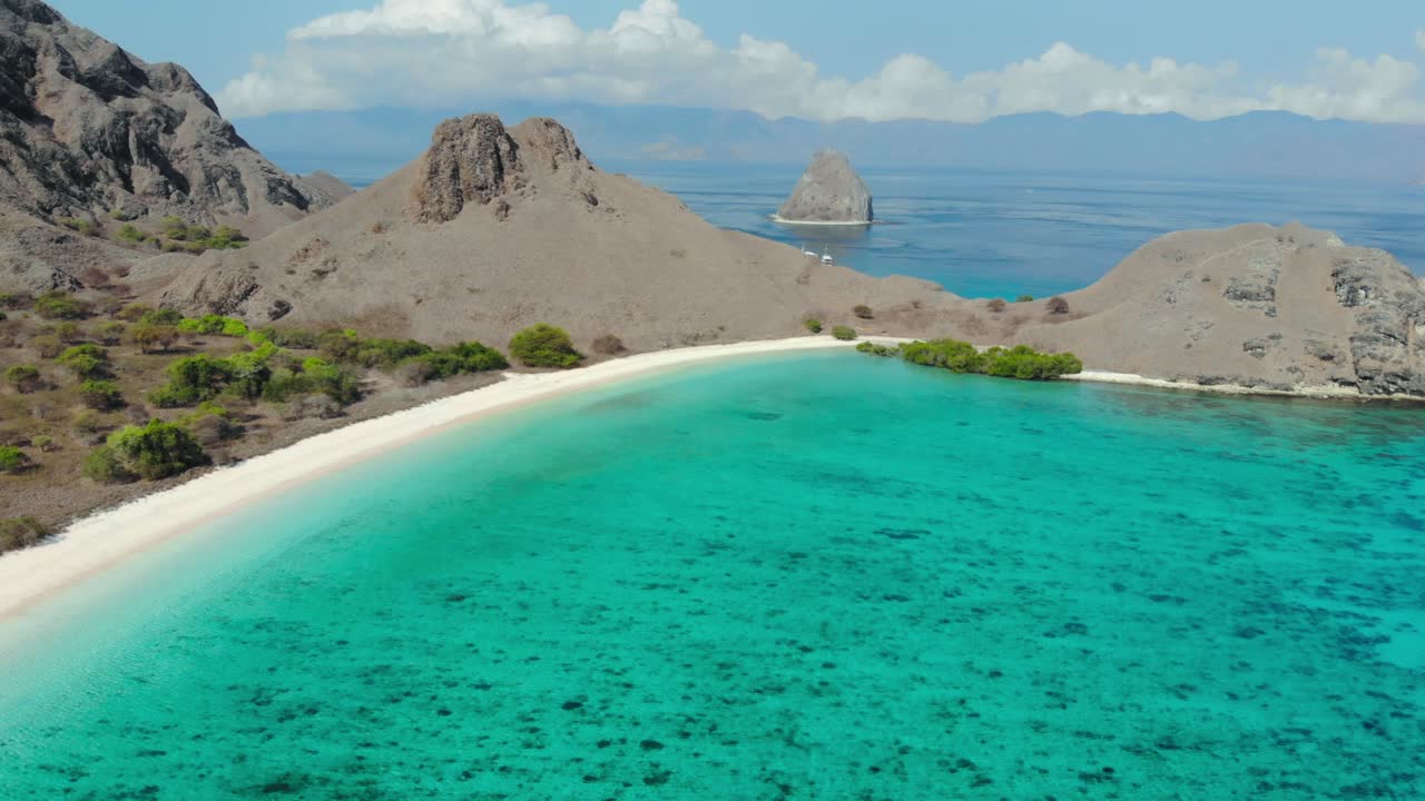Scenic View Of Pink Beach With Rugged Hills and turquoise water On The Padar Island In Komodo National Park, Indonesia