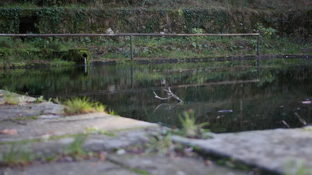 물이 떨어지는 배경에 천연 돌 파이프를 가진 오래된 물  ⁇ 크