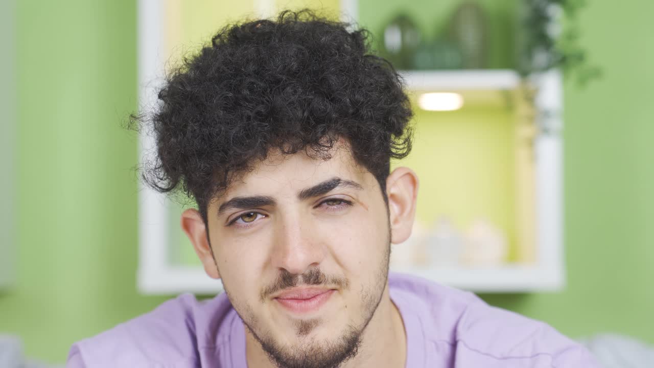 사려 깊은 십대가 웃고 긍정적인 표정으로 카메라를 쳐다보고 있습니다.