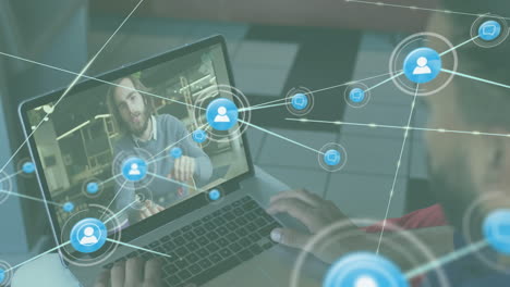 animación de una red de iconos digitales contra la vista trasera de un hombre biracial haciendo una llamada de video en una computadora portátil