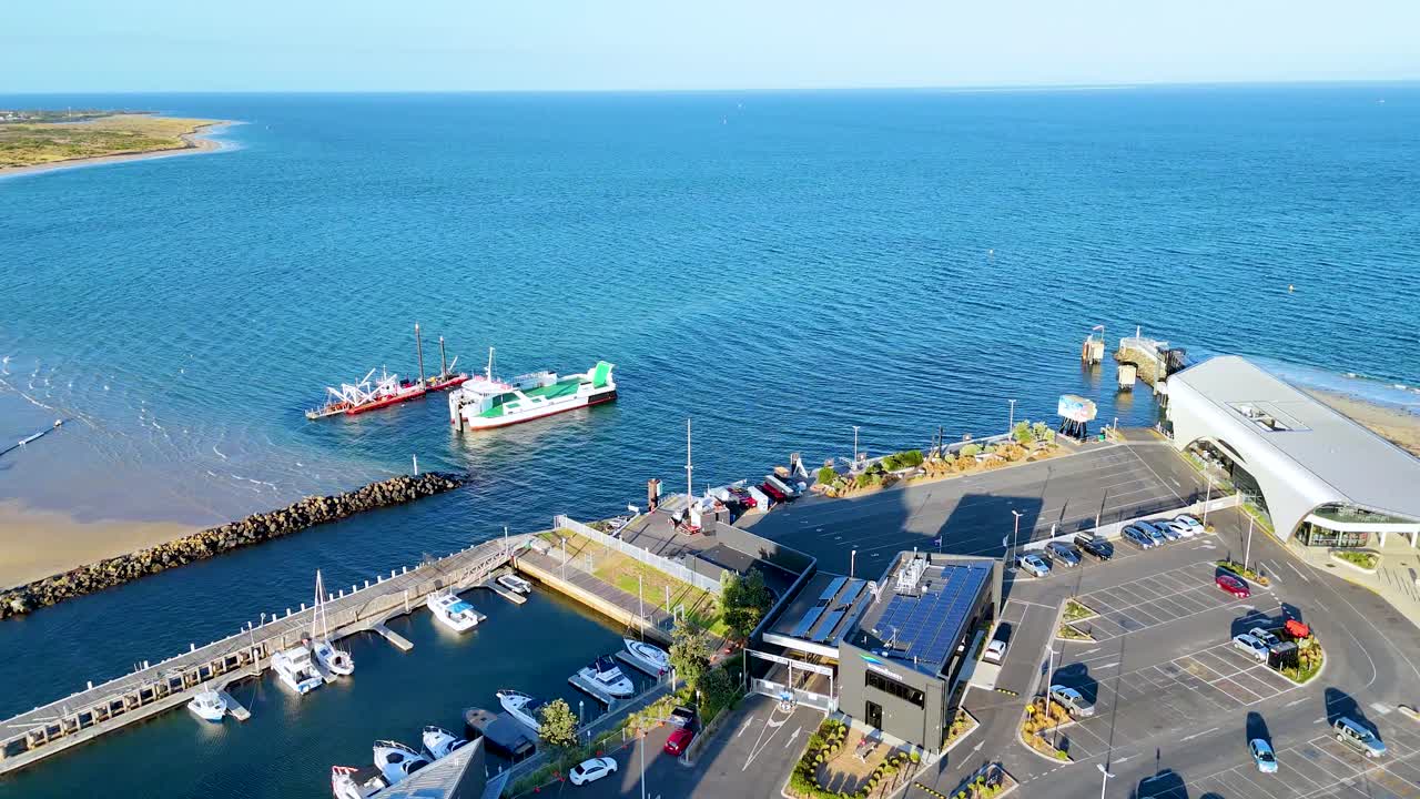 Drone captures vibrant port activity with ferries and clear blue waters in Bellarine, Victoria, under bright daylight