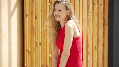 woman in red dress by wooden fence