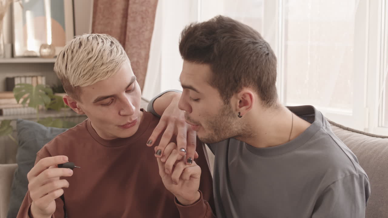 Two Young Men Applying Nail Polish and Laughing