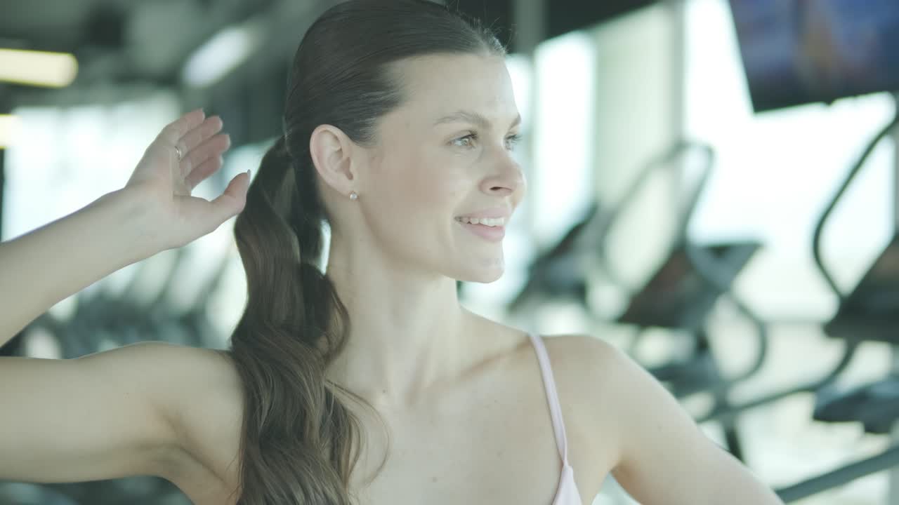 Woman in gym adjusting her hair