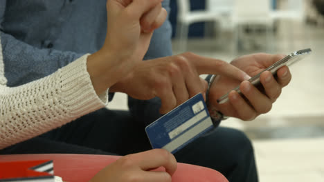 pareja con teléfono inteligente y tarjeta de crédito discutiendo