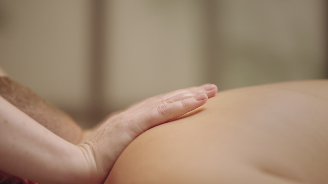 masaje ayurvédico para la salud espinal hombre se está relajando en la clínica osteopática masajista está acariciando la espalda y los hombros