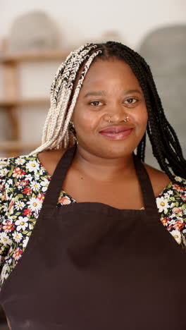 happy african american woman standing and smiling in pottery studio, slow motion