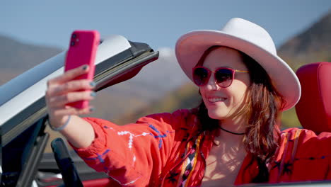 woman taking a selfie in a convertible car