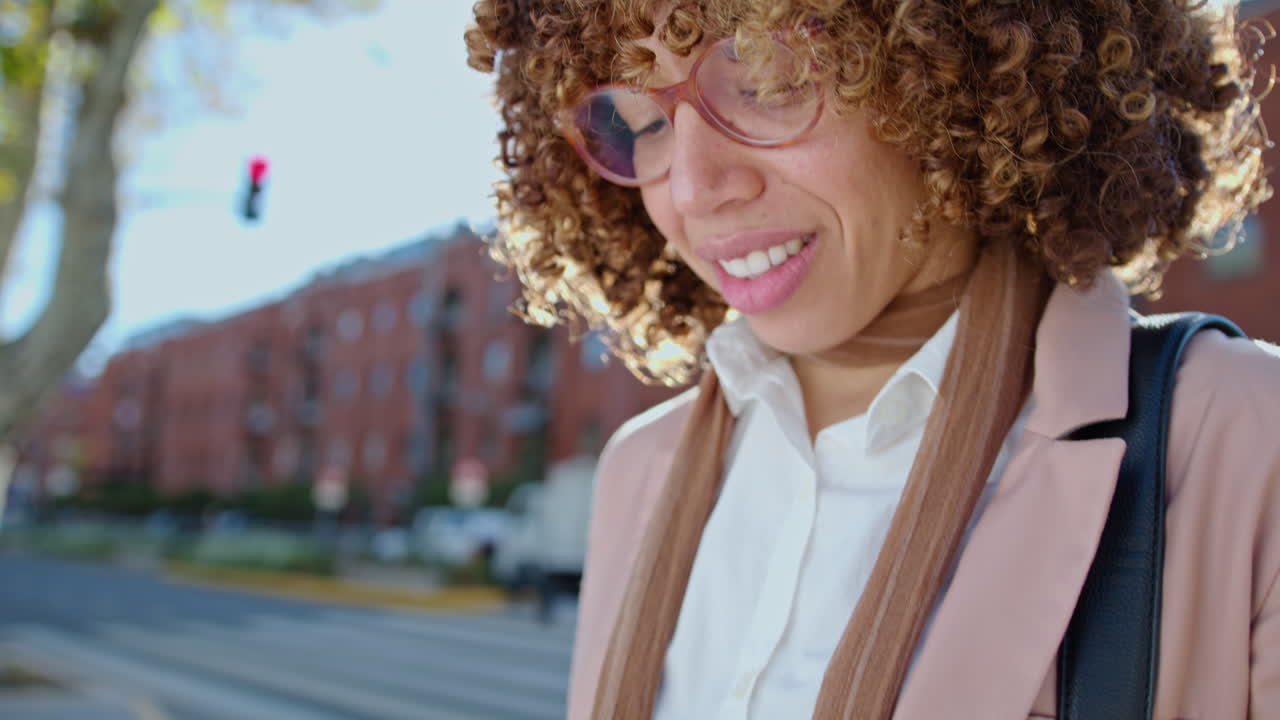Smiling Businesswoman Standing on the Street and Texting on Smartphone