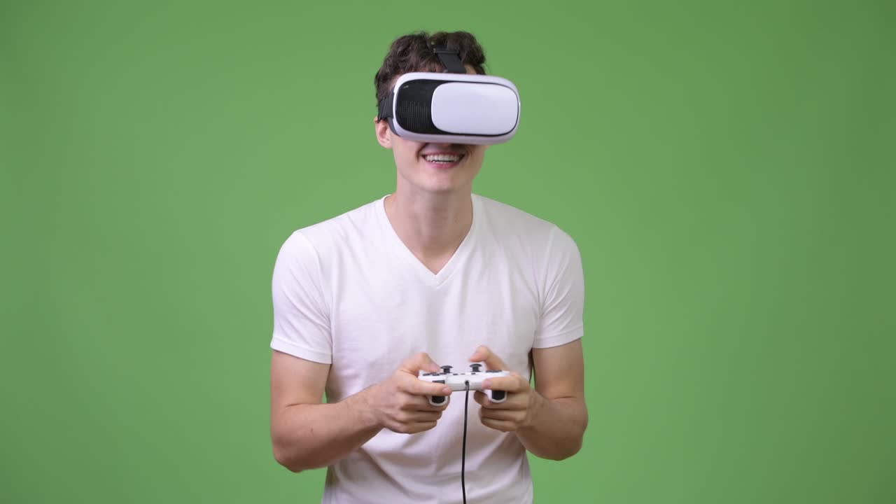 Giovane uomo affascinante che gioca ai videogiochi mentre usa un visore per la realtà virtuale