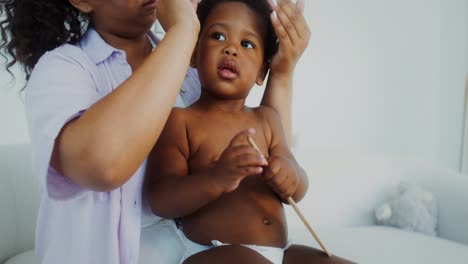 mother combing baby's hair