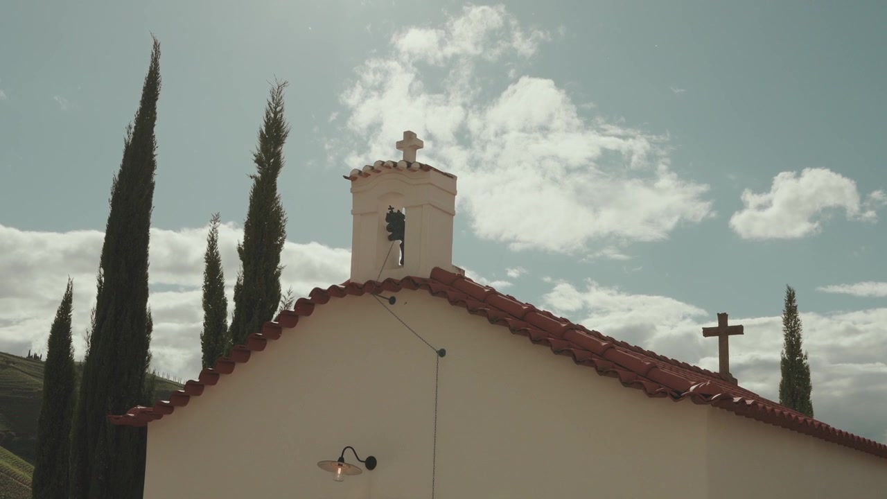 Piccola cappella bianca con campanile e croci si erge tra i cipressi nel Douro
