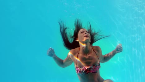 Brunette-swimming-underwater-in-the-pool