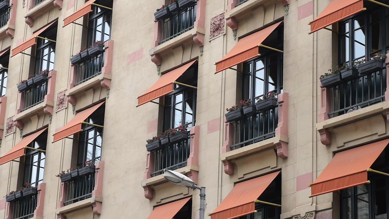 Vista esterna di un edificio classico con tende da sole arancioni