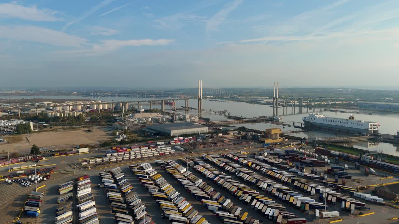 Pemandangan udara dari drone terhadap infrastruktur pelabuhan industri di sepanjang Sungai Thames dengan Jembatan Queen Elizabeth dan terowongan Dartford saat matahari terbenam di larut sore, London, Inggris Raya