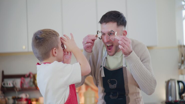 Dad And Son Playfully Bake Christmas Cookies Together