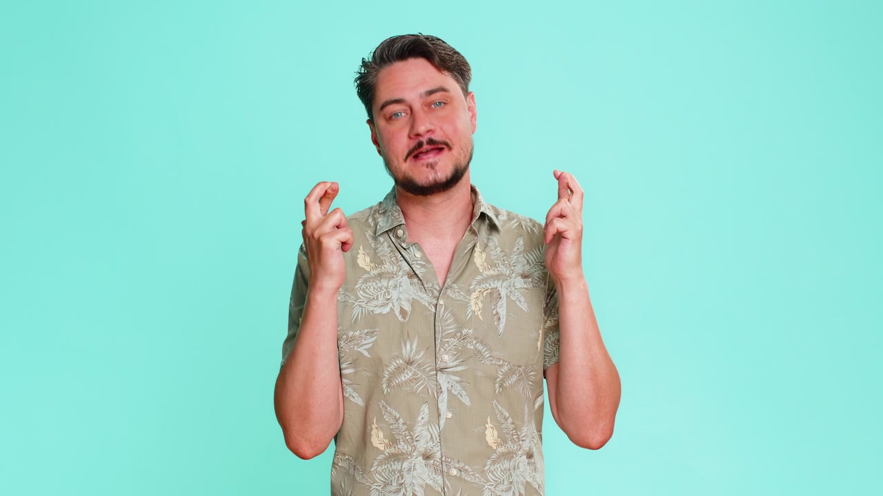 Uomo adulto che incrocia le dita, sperando in un esito positivo, con un'emozione nervosa e un gesto di speranza
