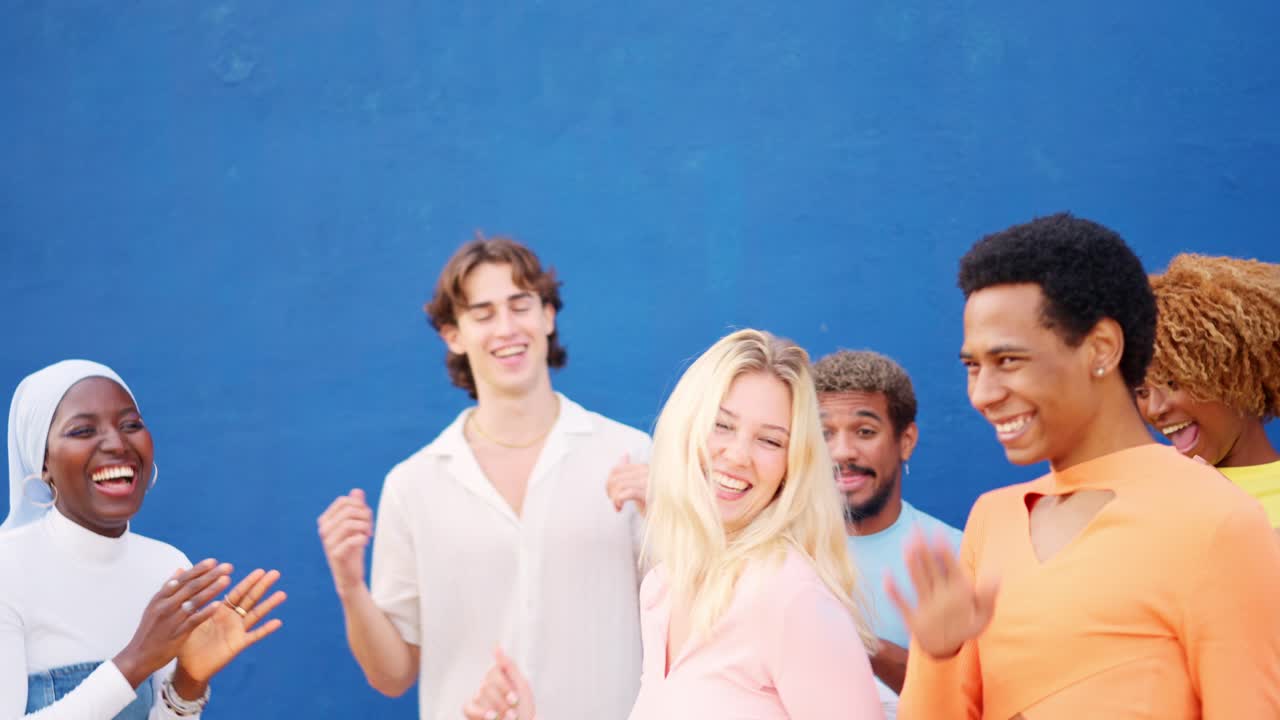 Two friends dancing next to multi-ethnic friends outdoors