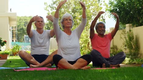 Senior-friends-performing-yoga-in-garden-4k