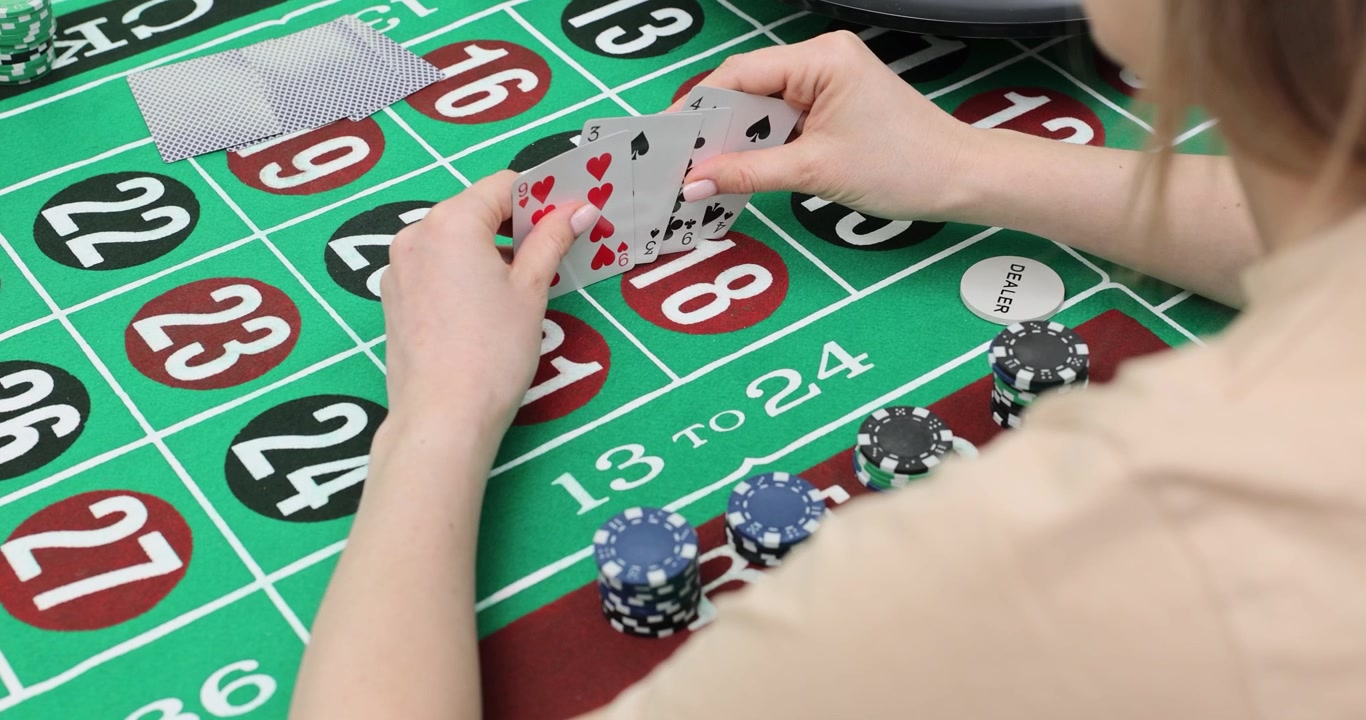 Donna guarda le carte da gioco su un tavolo da roulette verde in un casinò